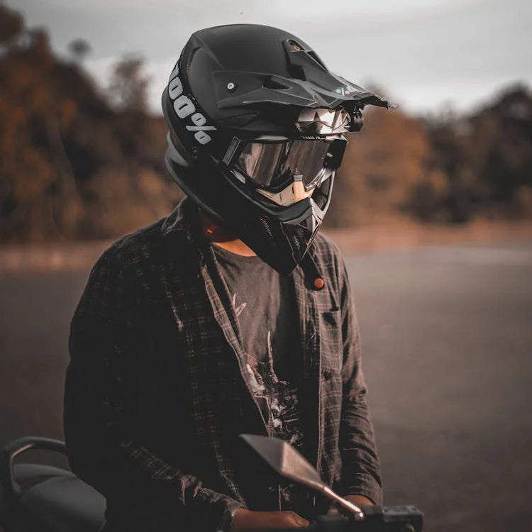 Motociclista com capacete integral e viseira, sentado na mota