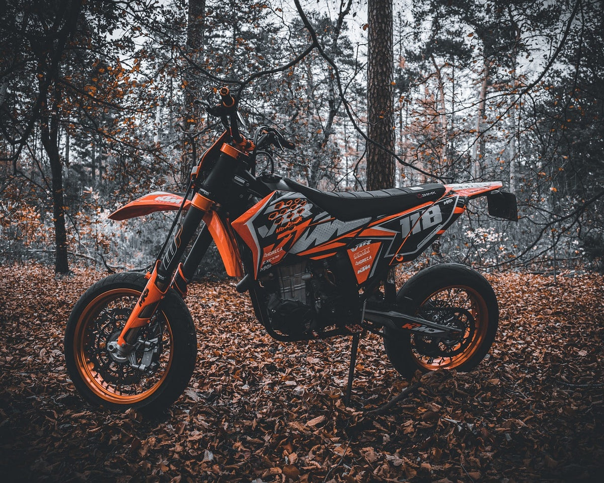 Mota KTM de enduro parada numa floresta de outono