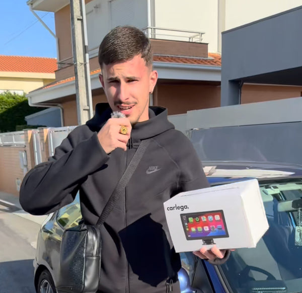 Cliente jovem a segurar a caixa do ecrã Carlega junto ao seu carro