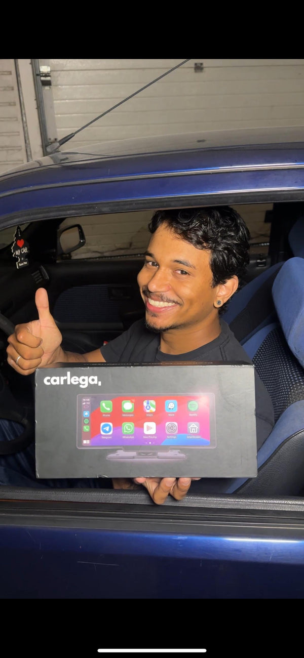 Cliente a fazer polegar para cima dentro do carro, com a caixa do Carlega na mão