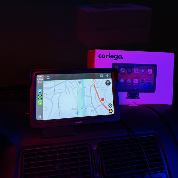 Dois ecrãs Carlega ligados dentro do carro à noite, iluminados por luz neon roxa