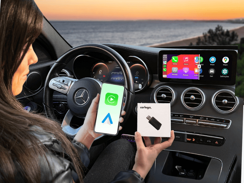 Condutora dentro de um Mercedes com o telemóvel numa mão e a caixa da Pen Carlega na outra