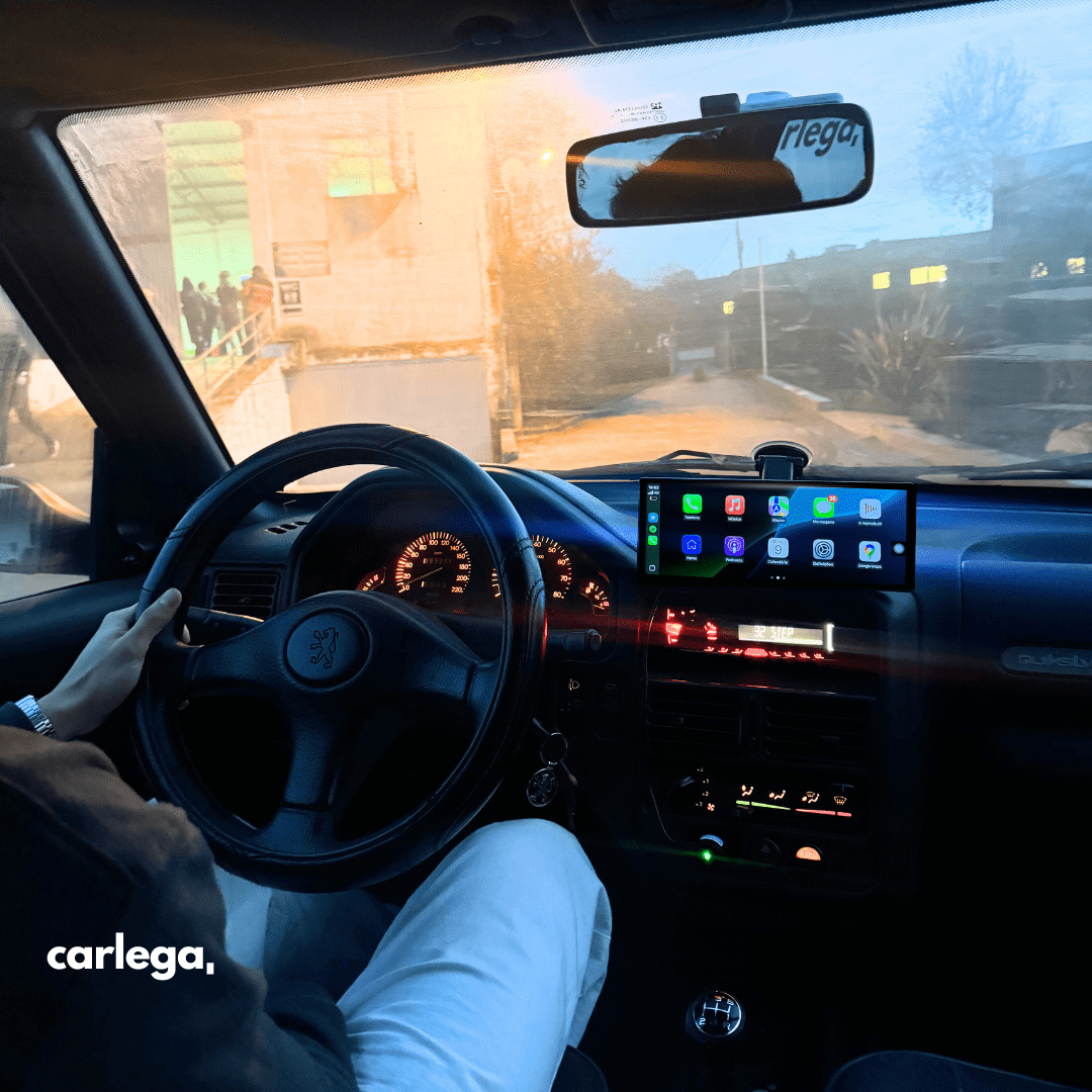 Condutor ao volante com o ecrã Carlega PRO ligado no tablier, ao anoitecer